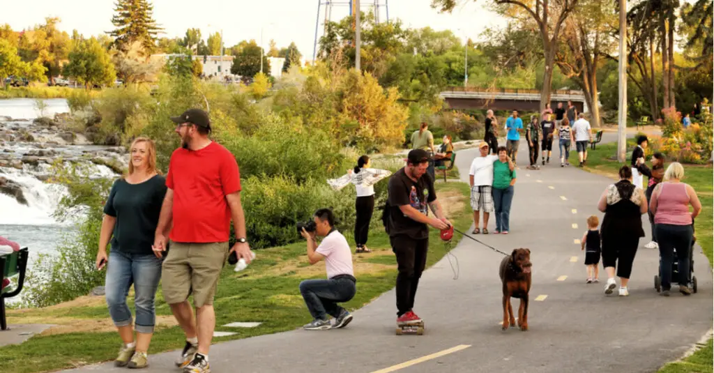 A crowd of people stroll along the Idaho Falls Greenbelt Trail in Idaho Falls, Idaho.