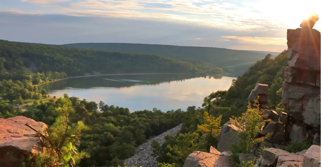 A view of a lake from a rocky ledge at sunset, in Devil's Lake State Park in Wisconsin